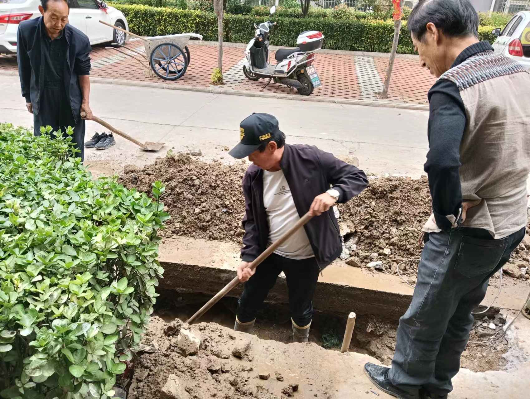 民心家园小区主任带头挖沟找水管漏点.jpg